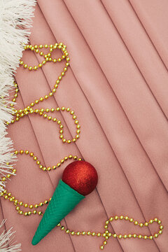 Flat lay Christmas and chinese new year scene icecram cone in silk background winter moode wiht glitters.  Xmas decoration concept with copy space. Minimal colored with christmas baubles.