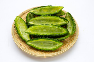 Bitter gourd in bamboo basket on white background.
