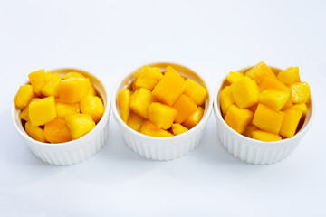 Tropical fruit, Mango cube slices in white cups on white background.