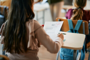 Cloe-up of schoolgirl gets A+ grade on test at elementary school.