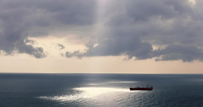 Aerial view of a single big cargo ship on the sea over cloudy blue sky stock photo