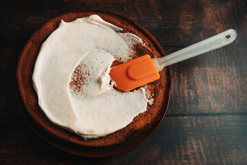 Carrot cake on a large plate. Creamy mascarpone cream on a chocolate cake.