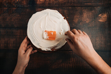 Carrot cake on a large plate. Creamy mascarpone cream on a chocolate cake.