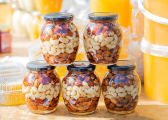Jar of honey and nuts on a light background. Selective focus