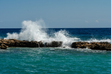 Sea waves break at rock during storm