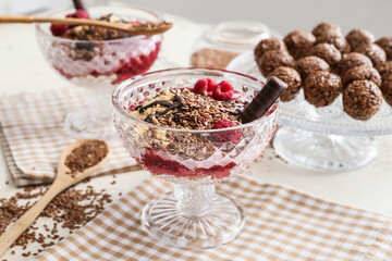 Tasty dessert with flax seeds and yoghurt in glass on table