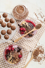 Tasty desserts with flax seeds on light background