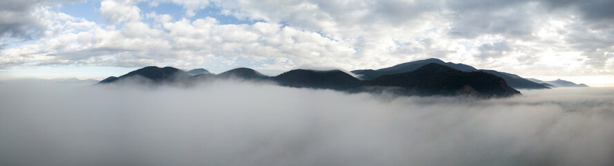 Panoramic aerial view of a mountain in the fog, Tuscany, Italy