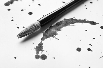 Ink spots and brush for calligraphy on white paper