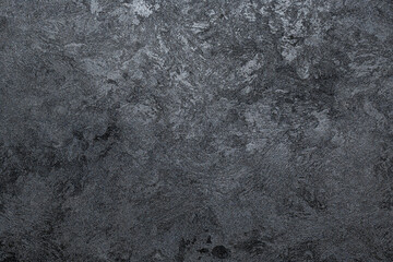 Fototapeta na wymiar Textured dark background. Decorative plaster walls, wallpaper. Black texture decorative plaster walls