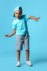 Fototapeta na wymiar Cute dancing African-American boy on color background
