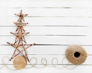 Christmas tree made of wooden stars and jute rope on a white wooden background. Zero waste. DIY.