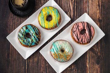 Delicious donuts decorated with different decorations on wooden table