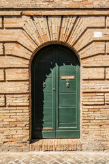 Background with green front door and brick wall of a house