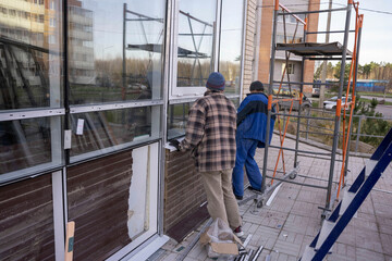 Fototapeta na wymiar Replacement of double-glazed windows in shop windows, reconstruction of the supermarket facade, repair of windows