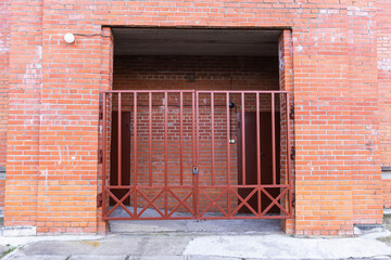 Iron lattice gates in the arch of a modern brick residential building
