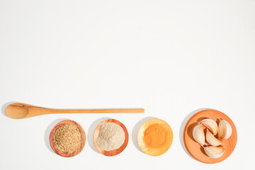 the variety of spices and herbs on a white background with copy space. a simple culinary background suitable for social media post or website presentation.