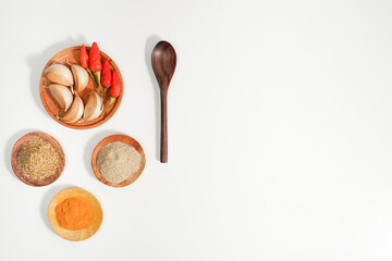 the assortment of spices and herbs on a white background with copy space. a simple culinary background suitable for social media post or website presentation.