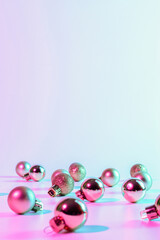 Christmas balls pattern neon background. Xmas bauble on abstract holiday winter gradient backdrop. Happy new year copy space.