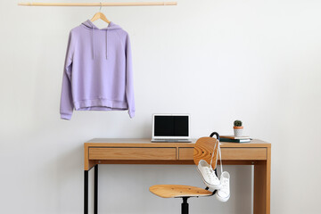 Workplace near wall with hanging hoodie