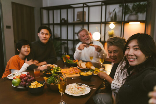 Asian family having taking selfie before dinner at dining table at home