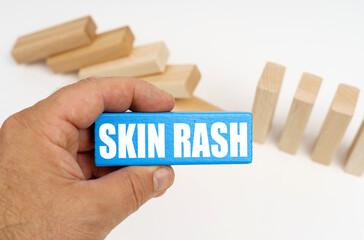 The man is holding a blue plaque with the inscription - skin rash