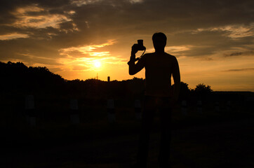 Fototapeta premium Silhouette of a photographer against sunset sky 