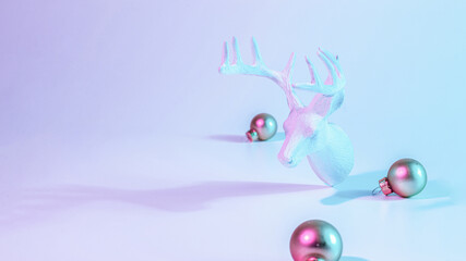 Christmas animal neon winter background. Holiday decoration bauble ball on neon gradient backdrop. Minimal abstract xmas reindeer. Happy new year copy space.