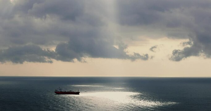 Aerial view of a single big cargo ship on the sea over cloudy blue sky stock photo