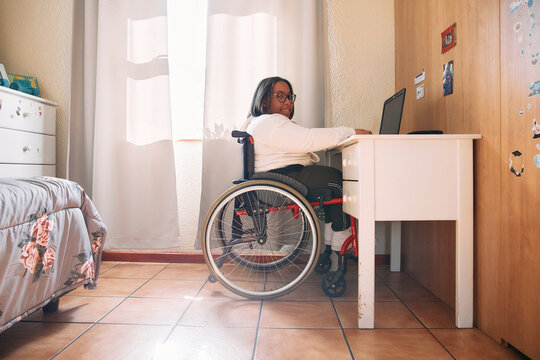 person in wheelchair studying at home