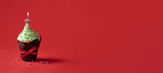 Christmas cupcake with green cream top and star candle.