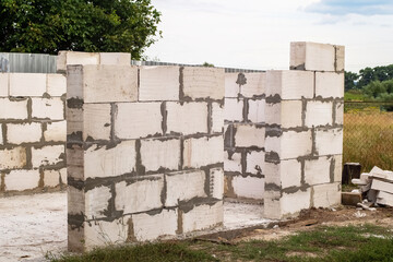 Unfinished walls made of white aerated concrete blocks. Construction site of a utility room under construction. Engineering, technology, construction. Foam concrete block.