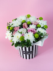 Beautiful tender bouquet of white and rose flowers in box on pink background. Selective focus.