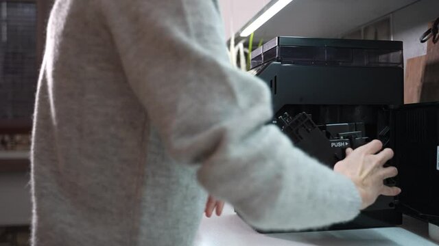 Woman has a coffee machine in the kitchen and she wants to service it. Woman opens a coffee machine and removes a brewing unit to clean it. High quality 4k footage