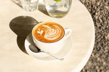 Cup of tasty coffee on table in outdoor cafe