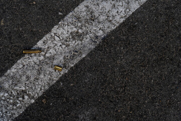 Two different caliber bullet shell casings on asphalt street