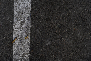 Fototapeta premium Two different caliber bullet shell casings on asphalt street
