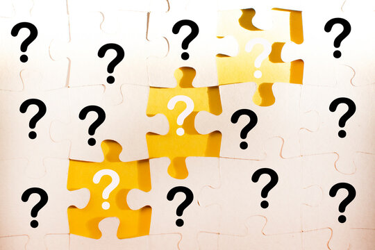 question marks and white jigsaw puzzle pieces on a yellow background. FAQ, Business solution concept