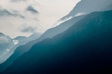 Mountain silhouettes. Misty mountain silhouette with clouds in full frame