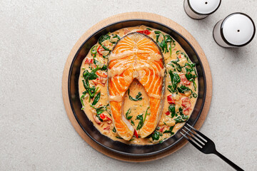 Creamy garlic butter tuscan salmon. Pan seared salmon in a delicious creamy sauce with spinach and sun dried tomatoes. Top view.