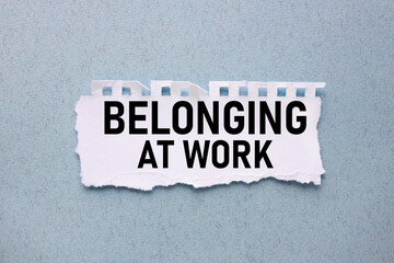 BELONGING AT WORK. text on white torn paper on blue background