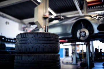 Tyre change - wheel balancing or repair and change car tire at auto service garage or workshop by mechanic - obrazy, fototapety, plakaty