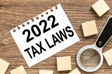 2022 TAX LAWS. white paper text on wood table