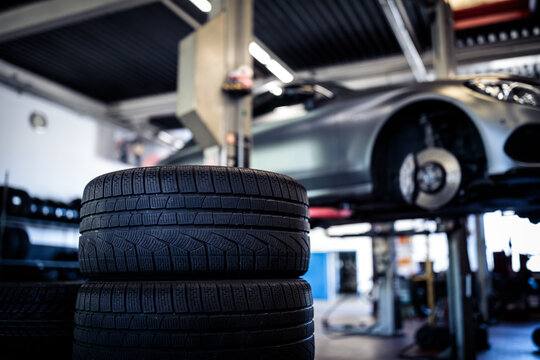 Tyre change - wheel balancing or repair and change car tire at auto service garage or workshop by mechanic
