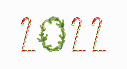 Numbers 2022 from traditional Christmas candy cane, green spruce branches, white marshmallows on white background. New Year 2021. Winter concept, objects for design, holiday symbol, decoration
