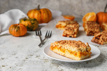 Plate with piece of fresh pumpkin pie on light background