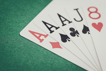 Playing cards and board game figures arranged on a poker table in a casino. Poker card game, winning combination.