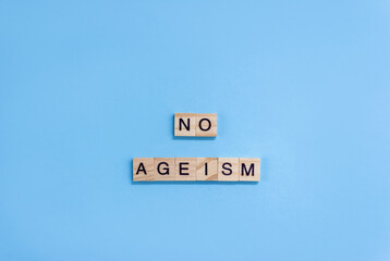 Words No Ageism. Wooden blocks with letters on blue background. Age equality concept. Copy space