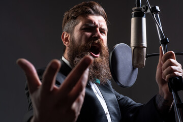 Classic singer in suit. Man singing with music microphone.