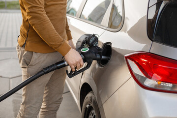 Car refueling on the petrol station. Man refilling the car with fuel. Close up view. Gasoline,...